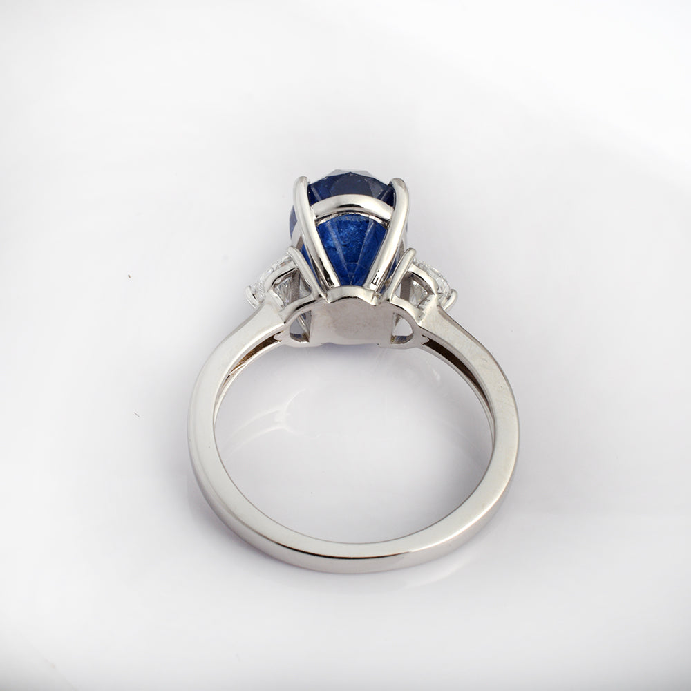 Natural blue sapphire engagement ring in 14K white gold with oval sapphire and pear diamonds, crafted by Ganpati.