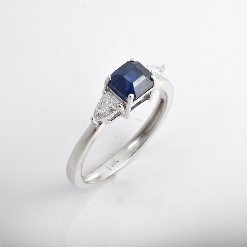 Blue sapphire engagement ring in 14K white gold with octagon cut sapphire and diamond side stones, art deco style.