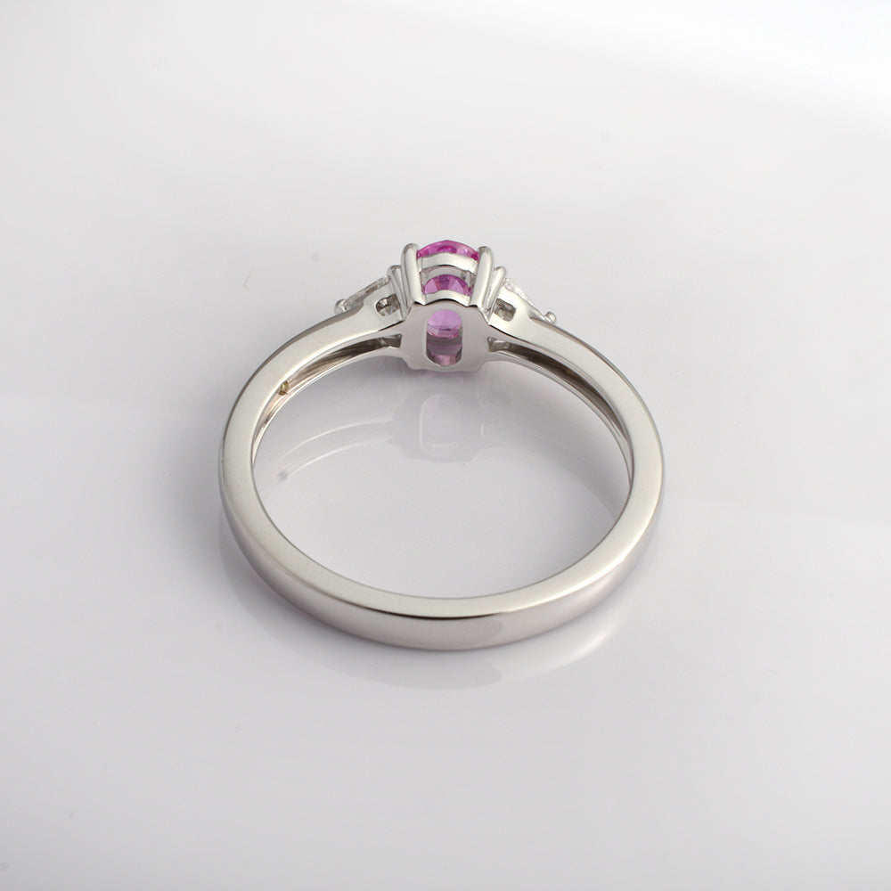 Pink sapphire and diamond ring in 14K white gold featuring an oval pink sapphire and three stones, by Ganpati.