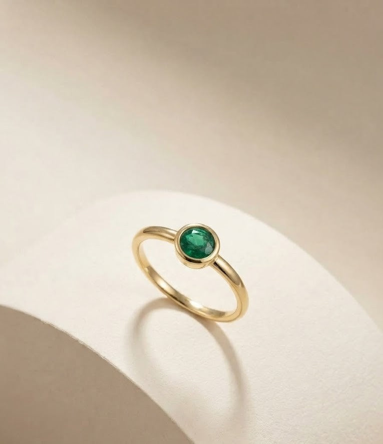 Natural emerald bezel ring by Ganpati with gold vermeil and sterling silver, features a round emerald solitaire in a minimalist design