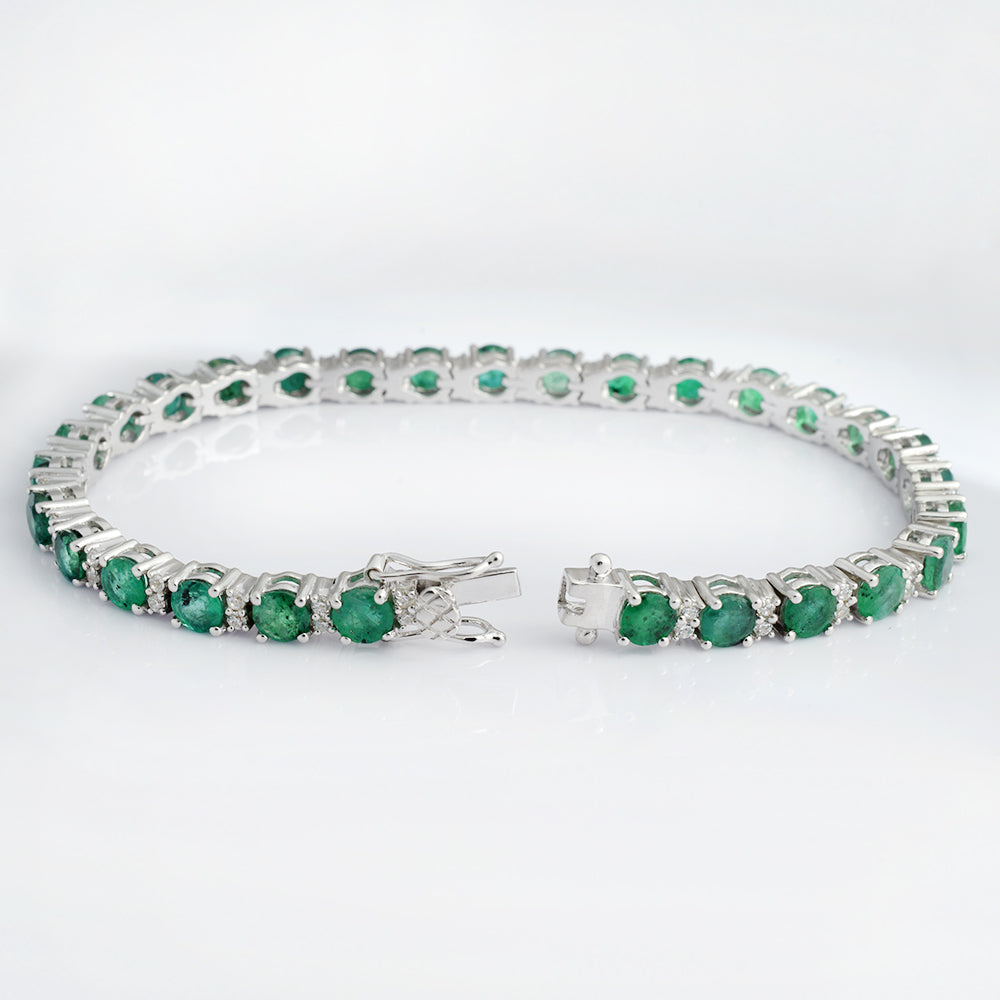 A silver tennis bracelet featuring round green emerald-cut gemstones, displayed on a clean white background.