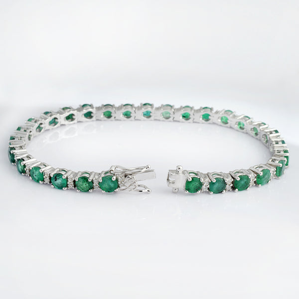 A silver tennis bracelet featuring round green emerald-cut gemstones, displayed on a clean white background.