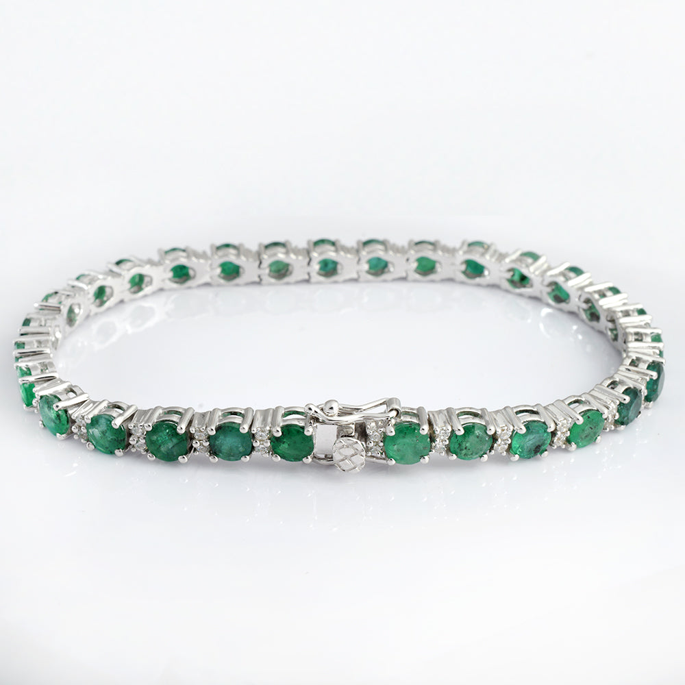 A silver tennis bracelet featuring round green emerald-cut gemstones, displayed on a clean white background.