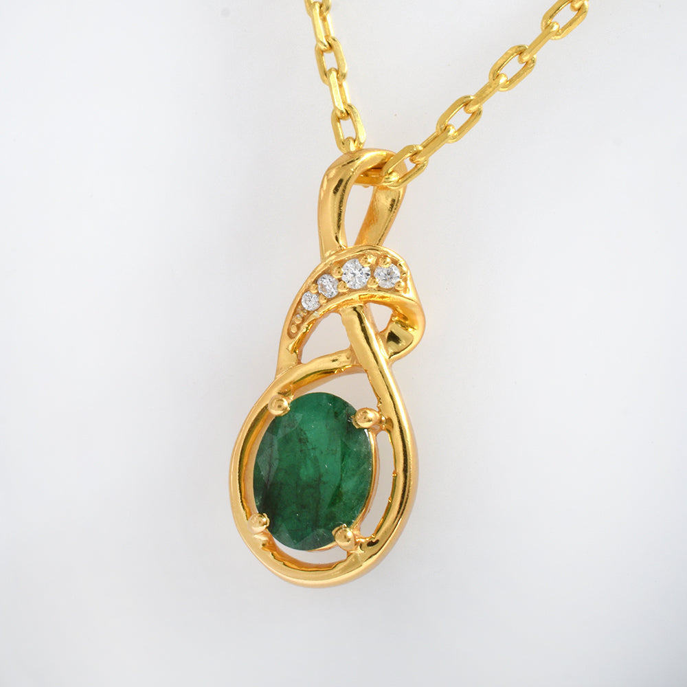 A gold pendant necklace featuring an oval green emerald-cut stone and a curved gold setting with small clear accent stones, shown on a plain white background.