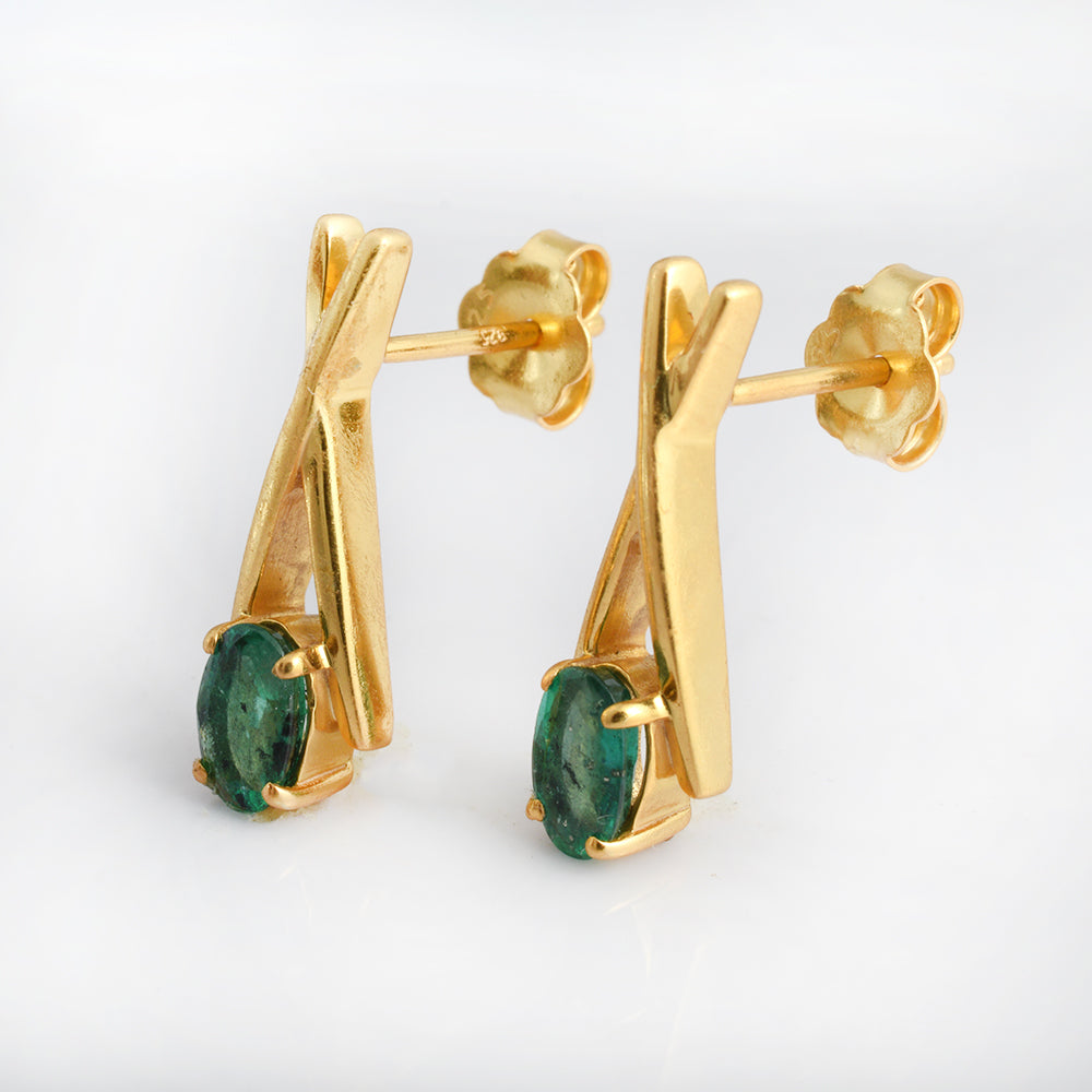 A pair of gold drop earrings with a twisted geometric design and oval green gemstones, shown on a clean white background.