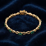 Natural emerald bracelet for women featuring oval green emeralds and infinity links in 925 sterling silver with 18K gold vermeil.
