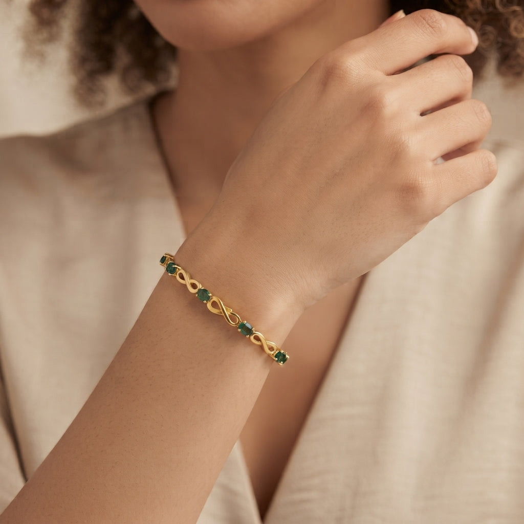 Natural emerald bracelet for women with oval green emeralds and infinity link, crafted in 925 sterling silver and 18K gold vermeil.