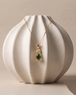 Ganpati natural emerald CZ infinity pendant with gold vermeil and 925 silver, featuring an oval green gemstone twist design.