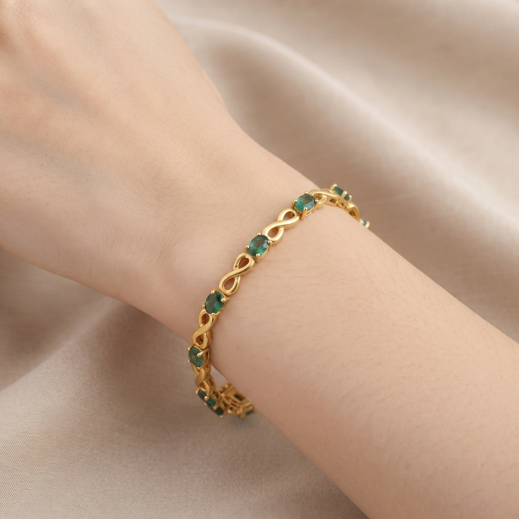 Natural emerald bracelet for women with oval green emeralds and infinity links in 925 sterling silver and 18K gold vermeil.