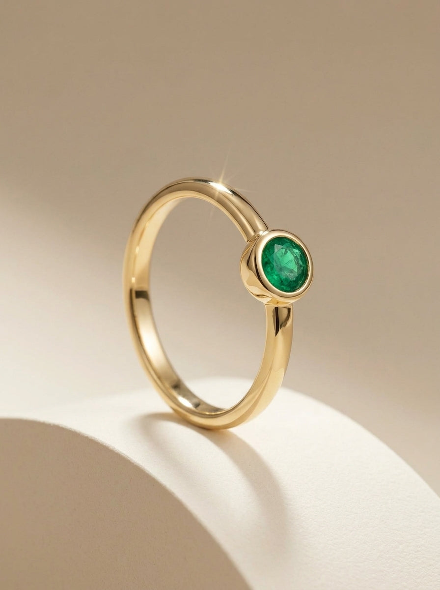 Natural emerald bezel ring with gold vermeil and sterling silver, featuring a round emerald solitaire on a dainty gold band.