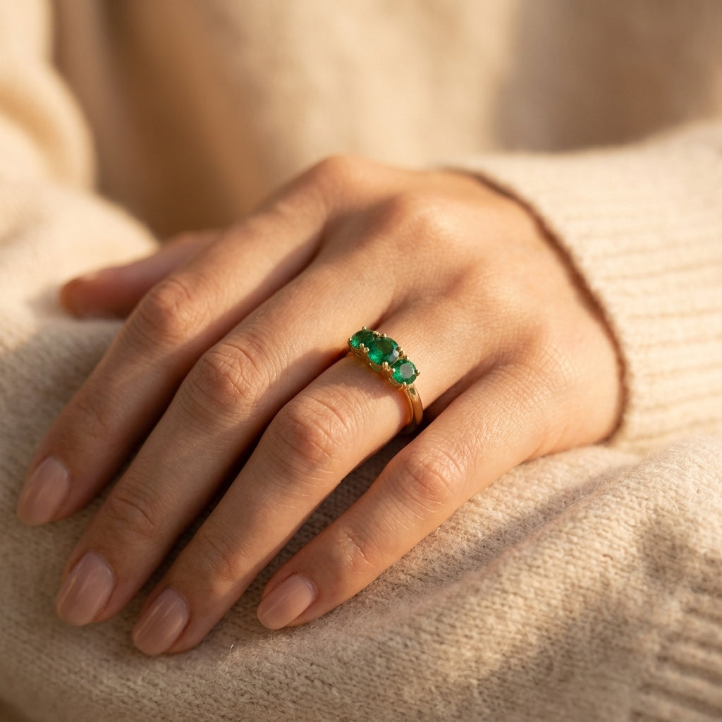 Natural emerald trilogy ring by Ganpati, gold vermeil with three round green emerald gemstones on 925 silver, worn by model.